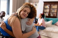 Supportive diverse female friends hugging each other at group therapy session. Therapy, mental health, friendship and support, unaltered.